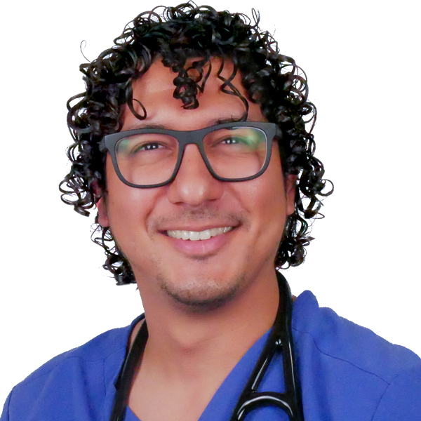 A man with very curl black hair and glasses in blue scrubs with a stethoscope.